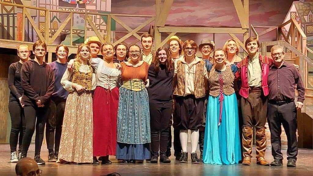 All the band students who are in musical with Nr. Collier. The students are in costume and the set for Something Rotten! is behind them.